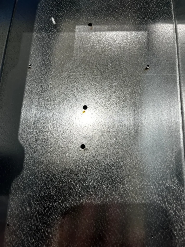 Inside a galvanized TRU-BOX enclosure showing ground-lug mounting holes